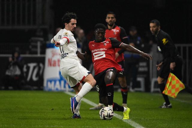 (From L) Paris Saint-Germain's Portuguese midfielder #17 Vitinha and Rennes' Cameroonian defender #18 Mahamadou Nagida fight for the ball during the French L1 football match between Stade Rennais FC and Paris Saint-Germain (PSG) at the Roazhon Park stadium in Rennes, western France, on February 13, 2026. (Photo by Damien MEYER / AFP)