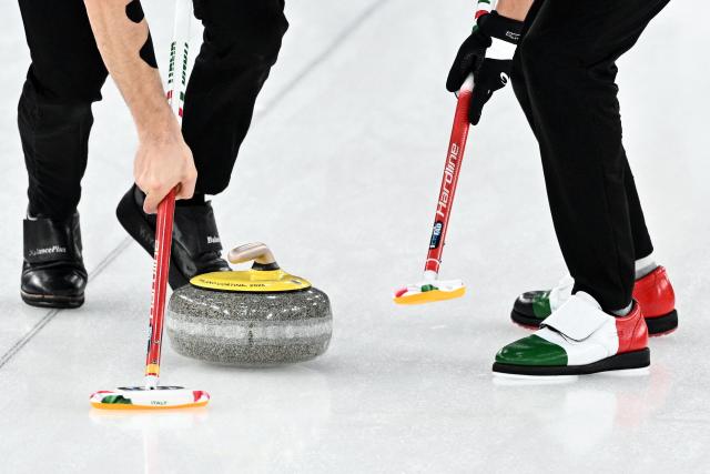 Italy's Sebastiano Arman (L) and Italy's Mattia Giovanella compete in the curling men's round robin between Germany and Italy during the Milano Cortina 2026 Winter Olympic Games at the Cortina Curling Olympic Stadium in Cortina d’Ampezzo on February 13, 2026. (Photo by Tiziana FABI / AFP)