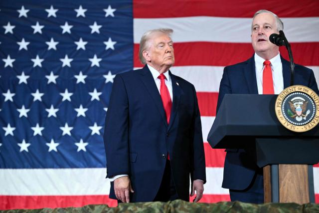 US President Donald Trump (L) looks on as Michael Whatley, former Republican National Committee Chairman and current candidate for US Senate in North Carolina, speaks to members of the military and their families at Fort Bragg, North Carolina on February 13, 2026. Trump will meet on Friday with the special forces soldiers who captured Venezuelan leader Nicolas Maduro in a deadly raid in Caracas in January. (Photo by Mandel NGAN / AFP)