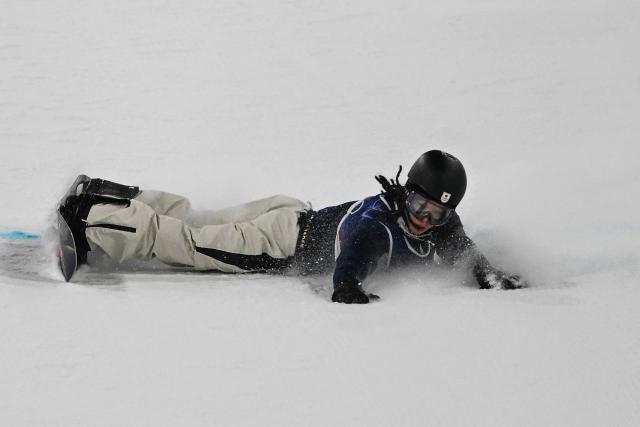 Japan's Ayumu Hirano reacts after falling while competing in the snowboard men's halfpipe final run 1 during the Milano Cortina 2026 Winter Olympic Games at Livigno Snow Park, in Livigno (Valtellina), on February 13, 2026. (Photo by Jeff PACHOUD / AFP)