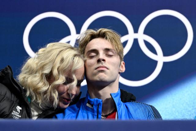 Estonia's Aleksandr Selevko (R) reacts in the kiss and cry area after competing in the figure skating men's singles free skating final during the Milano Cortina 2026 Winter Olympic Games at Milano Ice Skating Arena in Milan on February 13, 2026. (Photo by WANG Zhao / AFP)