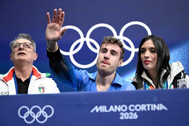 Italy's Matteo Rizzo (C) reacts in the kiss and cry area after competing in the figure skating men's singles free skating final during the Milano Cortina 2026 Winter Olympic Games at Milano Ice Skating Arena in Milan on February 13, 2026. (Photo by WANG Zhao / AFP)