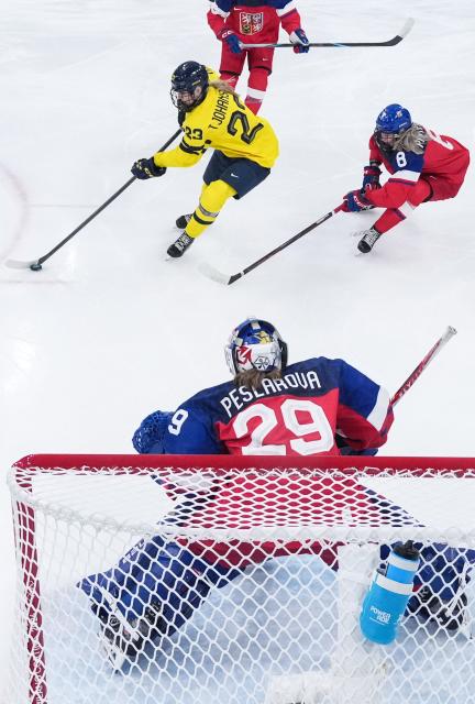 Sweden's #23 Thea Johansson (rear C) controls the puck past Czech Republic's #08 Tereza Pistekova (R) and in front of Czech Republic's #29 Klara Peslarova (C) during the women's quarter final Ice Hockey match between Czech Republic and Sweden at the Milano Rho Ice Hockey Arena at the Milano Cortina 2026 Winter Olympic Games in Milan, on February 13, 2026. (Photo by Wang Kaiyan / POOL / AFP)