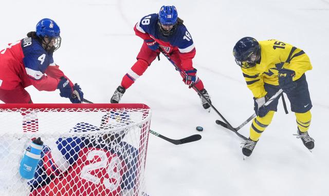 Sweden's #15 Lisa Johansson (R) fights for the puck with Czech Republic's #04 Daniela Pejsova (L), Czech Republic's #18 Michaela Pejzlova (C) and Czech Republic's #29 Klara Peslarova (front C) during the women's quarter final Ice Hockey match between Czech Republic and Sweden at the Milano Rho Ice Hockey Arena at the Milano Cortina 2026 Winter Olympic Games in Milan, on February 13, 2026. (Photo by Wang Kaiyan / POOL / AFP)