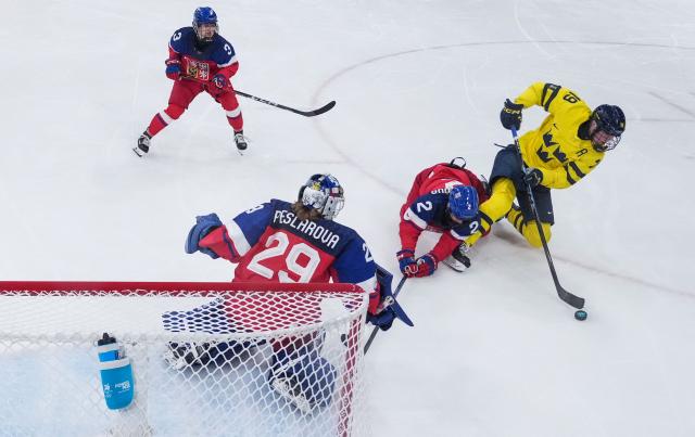 Czech Republic's #02 Aneta Tejralova (2nd R) body checks Sweden's #19 Sara Hjalmarsson (R) as they fight for the puck during the women's quarter final Ice Hockey match between Czech Republic and Sweden at the Milano Rho Ice Hockey Arena at the Milano Cortina 2026 Winter Olympic Games in Milan, on February 13, 2026. (Photo by Wang Kaiyan / POOL / AFP)