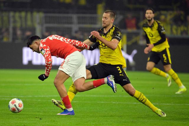 Dortmund's German defender #03 Waldemar Anton (R) and Mainz' German midfielder #10 Nadiem Amiri vie for the ball during the German first division Bundesliga football match between Borussia Dortmund and Mainz 05 in Dortmund, western Germany, on February 13, 2026. (Photo by Sascha Schuermann / AFP) / DFL REGULATIONS PROHIBIT ANY USE OF PHOTOGRAPHS AS IMAGE SEQUENCES AND/OR QUASI-VIDEO