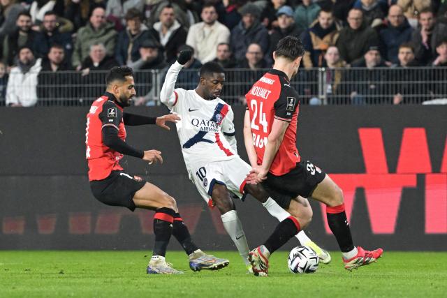 Rennes' Jordanian forward #11 Mousa Tamari (L), Paris Saint-Germain's French forward #10 Ousmane Dembele (C) and Rennes' French defender #24 Anthony Rouault fight for the ball during the French L1 football match between Stade Rennais FC and Paris Saint-Germain (PSG) at the Roazhon Park stadium in Rennes, western France, on February 13, 2026. (Photo by Damien MEYER / AFP)