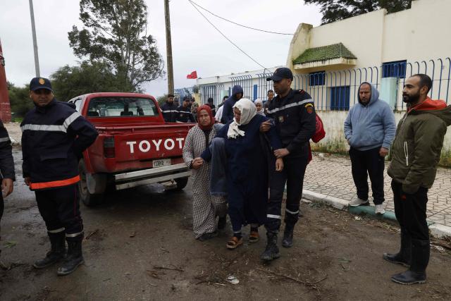 Members of the Royal Armed Forces (FAR), Civil Protection Services and local authorities assist in evacuating people affected by the flooding in the Sidi Slimane region, in northwestern Morocco on February 13, 2026. In Morocco, agriculture is a major sector, accounting for 12% of GDP and around a third of jobs. In recent weeks, the North African country has experienced unprecedented rainfall which, according to the government, has caused ‘the flooding of 110,000 hectares’ in the regions of Larache. (Photo by Abdel Majid BZIOUAT / AFP)