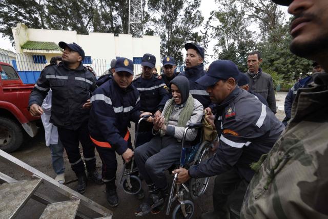 Members of the Royal Armed Forces (FAR), Civil Protection Services and local authorities assist in evacuating people affected by the flooding in the Sidi Slimane region, in northwestern Morocco on February 13, 2026. In Morocco, agriculture is a major sector, accounting for 12% of GDP and around a third of jobs. In recent weeks, the North African country has experienced unprecedented rainfall which, according to the government, has caused ‘the flooding of 110,000 hectares’ in the regions of Larache. (Photo by Abdel Majid BZIOUAT / AFP)