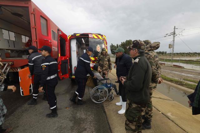 Members of the Royal Armed Forces (FAR), civil protection services and local authorities assist in evacuating people affected by the flooding in the Sidi Slimane region, in northwestern Morocco on February 13, 2026. In Morocco, agriculture is a major sector, accounting for 12% of GDP and around a third of jobs. In recent weeks, the North African country has experienced unprecedented rainfall which, according to the government, has caused ‘the flooding of 110,000 hectares’ in the regions of Larache. (Photo by Abdel Majid BZIOUAT / AFP)