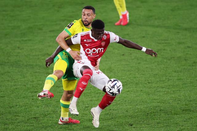Nantes' French midfielder #13 Francis Coquelin (L) fights for the ball with Monaco's Senegalese midfielder #15 Lamine Camara (R) during the French L1 football match between AS Monaco and  FC Nantes at the Stade Louis II in the Principality of Monaco on February 13, 2026. (Photo by Valery HACHE / AFP)