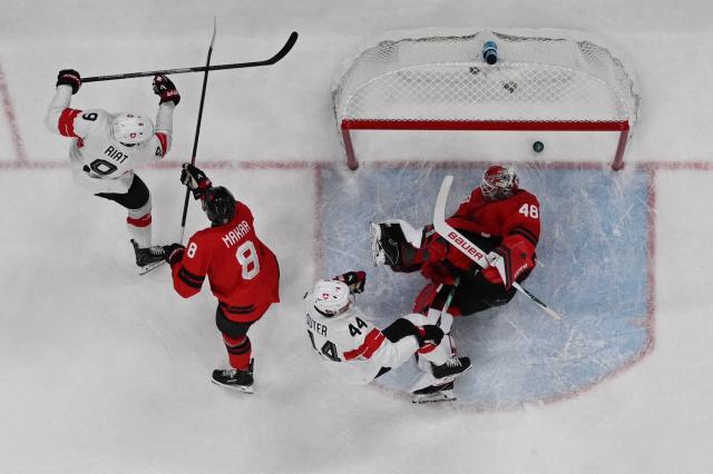 Switzerland's #44 Pius Suter (C) scores a goal  during the men's preliminary round Group A Ice Hockey match between Canada and Switzerland at the Milano Santagiulia Ice Hockey Arena during the Milano Cortina 2026 Winter Olympic Games in Milan, on February 13, 2026. (Photo by Alexander NEMENOV / AFP)