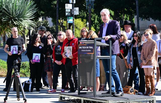 Bereaved parents gather behind James Holt, social psychologist and author of the book "The Anxious Generation," as he speaks at the opening of the "Lost Screen Memorial," a large-scale smartphones that features 50 children who have lost their lives to online harm, in Los Angeles, on Febuary 13, 2026. Meta and Google-owned YouTube were accused on February 9, 2026, of pushing highly addictive apps on children as a landmark social media trial began in earnest in a California court. The blockbuster trial in front of a Los Angeles jury could establish a legal precedent on whether the social media juggernauts deliberately designed their platforms to lead to addiction in children. (Photo by Frederic J. BROWN / AFP)