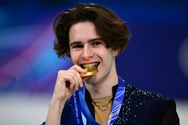Gold medallist Kazakhstan's Mikhail Shaidorov bites on his medal on the podium of the figure skating men's singles free skating final during the Milano Cortina 2026 Winter Olympic Games at Milano Ice Skating Arena in Milan on February 13, 2026. (Photo by Piero CRUCIATTI / AFP)