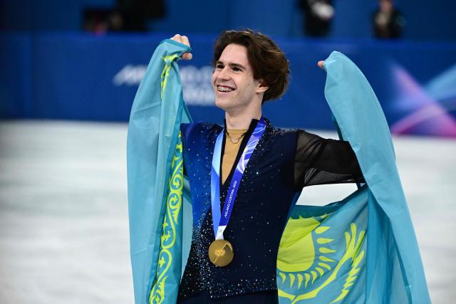 Gold medallist Kazakhstan's Mikhail Shaidorov poses with his country's flag following the victory ceremony of the figure skating men's singles free skating final during the Milano Cortina 2026 Winter Olympic Games at Milano Ice Skating Arena in Milan on February 13, 2026. (Photo by Piero CRUCIATTI / AFP)