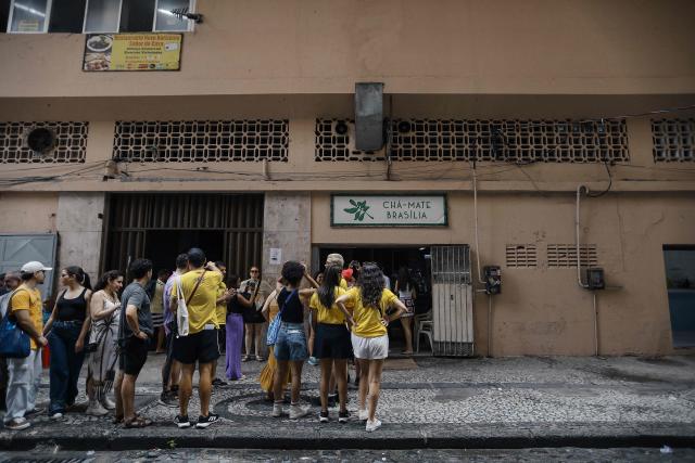 Tourists visit the Cha Mate Brasilia, a bar that is one the scenarios of the film "O Agente Secreto" (The Secret Agent) during a guided tour at the city center of Recife, Pernambuco state, Brazil, on February 13, 2026. For the second year in a row, a Brazilian movie has wowed international audiences and critics, securing multiple Oscar nominations and drawing fresh interest in the Latin American giant's film industry. Experts say the success of "The Secret Agent", which has won four Oscar nominations, a year after "I Am Still Here" won Brazil its first Oscar, is no fluke, with a bit of a push from the country's political climate. (Photo by BRENDA ALCANTARA / AFP)