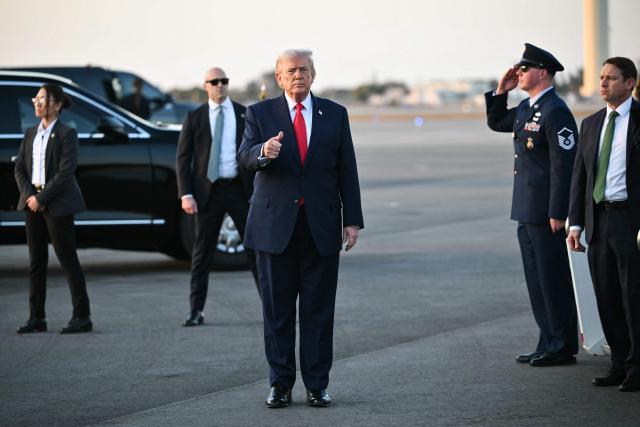 US President Donald Trump gestures toward the press after stepping off Air Force One at Palm Beach International Airport in West Palm Beach, Florida on February 13, 2026. Trump is spending the weekend at his Mar-a-Lago residence in Palm Beach. (Photo by Mandel NGAN / AFP)