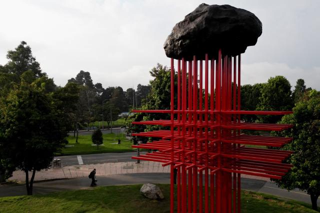This aerial view shows the New “Umbral” monument, which pays tribute to medical personnel who died during the Covid-19 pandemic, in Bogota on February 13, 2026. Created by Colombian artist Carlos Castro, it honors those who lost their lives during the pandemic. Standing over 11 meters high and 7 meters wide, it is represented by the universal symbol of the cross, an emblem conceived to protect life in hostile scenarios and, since its origins, to evoke the presence of medical personnel providing aid, neutrality, and humanity. (Photo by Raul ARBOLEDA / AFP)