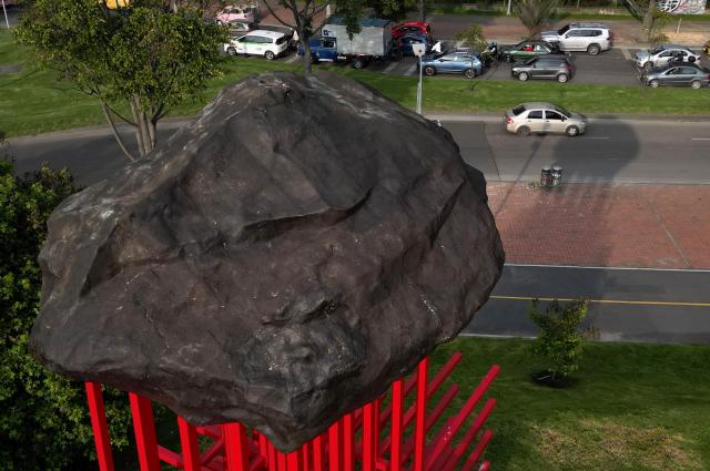 This aerial view shows the New “Umbral” monument, which pays tribute to medical personnel who died during the Covid-19 pandemic, in Bogota on February 13, 2026. Created by Colombian artist Carlos Castro, it honors those who lost their lives during the pandemic. Standing over 11 meters high and 7 meters wide, it is represented by the universal symbol of the cross, an emblem conceived to protect life in hostile scenarios and, since its origins, to evoke the presence of medical personnel providing aid, neutrality, and humanity. (Photo by Raul ARBOLEDA / AFP)