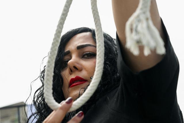 A member of the Iranian community holds a gallows rope as she marches during a rally in Sydney on February 14, 2026, calling for stronger international action and urging the United States to intervene against the current Iranian regime. (Photo by Saeed KHAN / AFP)