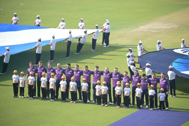 Scotland's players stand for their national anthem at the start of the 2026 ICC Men's T20 Cricket World Cup group stage match between England and Scotland at the Eden Gardens in Kolkata on February 14, 2026. (Photo by Dibyangshu SARKAR / AFP)