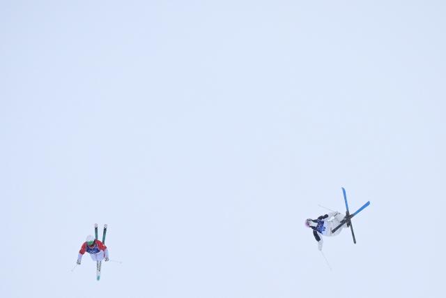 France's Camille Cabrol (L) and Japan's Rino Yanagimoto (R) compete in the freestyle skiing women's dual moguls last 32 during the Milano Cortina 2026 Winter Olympic Games at Livigno Aerials & Moguls Park, in Livigno (Valtellina), on February 14, 2026. (Photo by Kirill KUDRYAVTSEV / AFP)