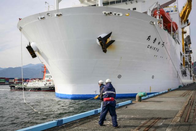 Members of staff work as Japan's deep-sea drilling vessel Chikyu returns to Shimizu port in Shimizu, Shizuoka prefecture on February 14, 2026. (Photo by Yuichi YAMAZAKI / AFP)
