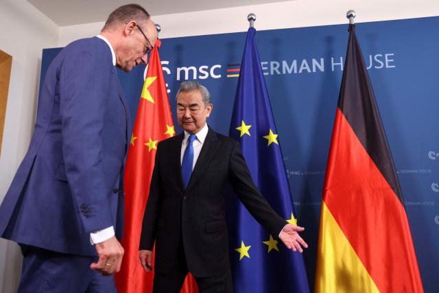 German Chancellor Friedrich Merz (L) and Chinese Foreign Minister Wang Yi meet for bilateral talks during the 62nd Munich Security Conference (MSC) on February 14, 2026 in Munich, southern Germany. (Photo by Thilo Schmuelgen / POOL / AFP)