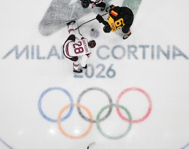 Latvia's #28 Zemgus Girgensons and  Germany's #29 Leon Draisaitl vie during the men's preliminary round Group C Ice Hockey match between Germany and Latvia at the Milano Rho Ice Hockey Arena during the Milano Cortina 2026 Winter Olympic Games in Milan, on February 14, 2026. (Photo by Alexander NEMENOV / AFP)