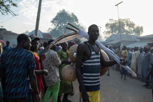 A fisherman poses for a portrait with a fishing net and a calabash before attending the Argungu Fishing and Cultural Festival at Argungu Town, Kebbi State in northwestern Nigeria, on February 14, 2026. (Photo by TOYIN ADEDOKUN / AFP)