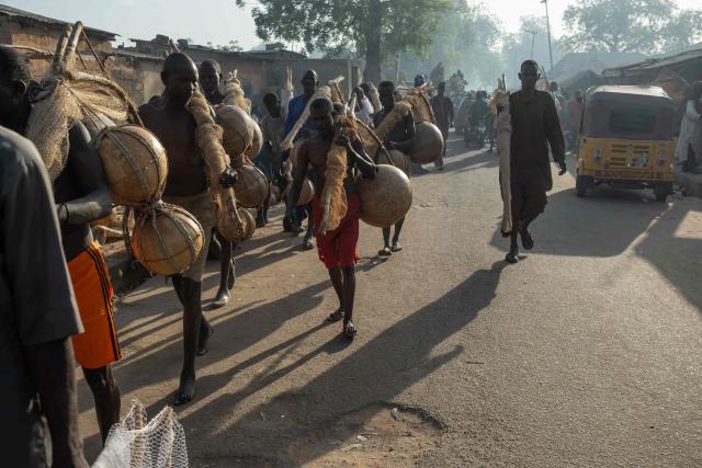 Fishermen carry calabash and fishing nets as they get ready to attend the Argungu Fishing and Cultural Festival at Argungu Town, Kebbi State in northwestern Nigeria, on February 14, 2026. (Photo by TOYIN ADEDOKUN / AFP)