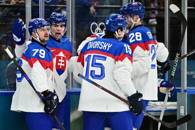 (From L) Slovakia's #79 Libor Hudacek, Slovakia's #17 Simon Nemec, Slovakia's #15 Dalibor Dvorsky and Slovakia's #28 Martin Gernat celebrate after the team's first goal by Slovakia's #20 Juraj Slafkovsky (not in picture) during the men's preliminary round Group B Ice Hockey match between Sweden and Slovakia at the Milano Santagiulia Ice Hockey Arena during the Milano Cortina 2026 Winter Olympic Games in Milan, on February 14, 2026. (Photo by JULIEN DE ROSA / AFP)