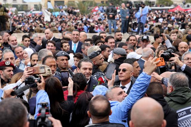 Saad Hariri (C), former Lebanese prime minister and the son of the late premier Rafic Hariri, is surrounded by security and supporters during a rally marking the 21st anniverary of his father's assassination, at Martyrs’ Square in central Beirut on February 14, 2026. Supporters and political figures attended a rally marking the anniversary where his son delivered a speech at his gravesite, recalling his political legacy and reaffirming commitment to national principles. (Photo by ANWAR AMRO / AFP)