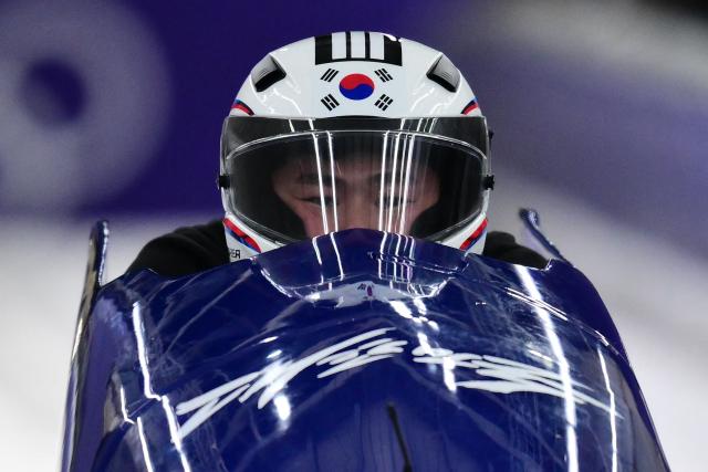 South Korea's Suk Youngjin pilots in the bobsleigh men's 2-man training session at Cortina Sliding Centre during the Milano Cortina 2026 Winter Olympic Games in Cortina d'Ampezzo on February 14, 2026. (Photo by Stefano RELLANDINI / AFP)