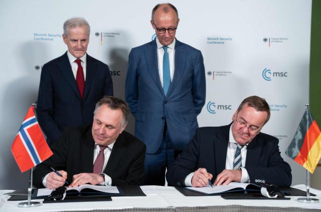 Norwegian Prime Minister Jonas Gahr Store (L) and German Chancellor Friedrich Merz watch as Norway's Defence Minister Tore O. Sandvik (bottom L) and German Defence Minister Boris Pistorius sign documents during the 62nd Munich Security Conference (MSC) on February 14, 2026 in Munich, southern Germany.  (Photo by Michael BIHLMAYER / POOL / AFP)