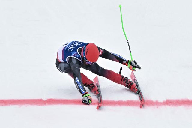Austria's Marco Schwarz lunges across the finish line in the second run of the men's giant slalom alpine skiing event during the Milano Cortina 2026 Winter Olympic Games at the Stelvio Ski Centre in Bormio (Valtellina) on February 14, 2026. (Photo by Fabrice COFFRINI / AFP)