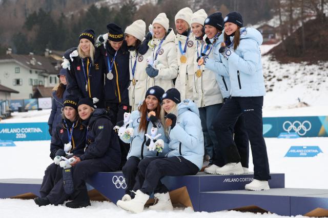 (From L) Silver medallists Sweden's Jonna Sundling, Sweden's Frida Karlsson (Top) and Sweden's Ebba Andersson and Sweden's Linn Svahn (Bottom), gold medallists Norway's Heidi Weng, Norway's Karoline Simpson-Larsen, Norway's Astrid Oeyre Slind and Norway's Kristin Austgulen Fosnaes, and Bronze medallists Finland's Jasmi Joensuu and Finland's Vilma Ryytty (Bottom) and Finland's Kerttu Niskanen and Finland's Johanna Matintalo celebrate on the podium for the cross-country women's 4 x 7,5km relay event of the Milano Cortina 2026 Winter Olympic Games at Tesero Cross-Country Skiing Stadium in Lago di Tesero (Val di Fiemme), on February 14, 2026. (Photo by Anne-Christine POUJOULAT / AFP)