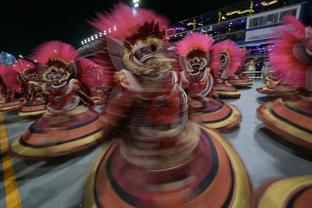 This slow shutter speed photography shows revellers of the Dragoes da Real samba school performing during the carnival parade at the Anhembi Sambadrome in Sao Paulo, Brazil, on February 14, 2026. (Photo by NELSON ALMEIDA / AFP)