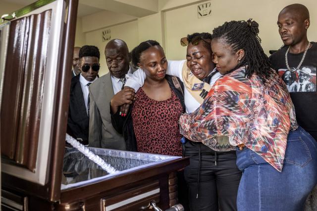 TOPSHOT - Relatives react as they view the remains of one of Kenya's last Mau Mau resistance fighters, Christopher Njora Muronyo, known as "General Kiambati", during his burial in Nyandarua County on February 14, 2026. Christopher Njora Muronyo died at the age of 106 in poverty, still carrying three bullets in his body from his time as a Mau Mau rebel against the British in the 1950s. His burial in the shadow of Kenya's Aberdare mountains was a modest affair. "General Kiambati", as he was known, was close to the iconic leader of the Mau Mau movement, Dedan Kimathi, who was executed in 1957. The rebellion began in 1952 in response to the massive takeover of land in central Kenya by British settlers, who turned the region into the "White Highlands". 
It was a key chapter in the road to independence in 1963, and the British response was one of the bloodiest episodes in its colonial history. (Photo by SIMON MAINA / AFP)