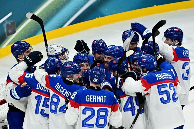 Slovakia's players celebrate after the men's preliminary round Group B Ice Hockey match between Sweden and Slovakia at the Milano Santagiulia Ice Hockey Arena during the Milano Cortina 2026 Winter Olympic Games in Milan, on February 14, 2026. Sweden won the match 5-3. (Photo by JULIEN DE ROSA / AFP)