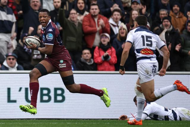 Bordeaux-Begles' French flanker Cameron Woki (L) runs with the ball on his way to scoring a try during the French Top 14 rugby union match between Union Bordeaux-Begles (UBB) and Castres Olympique at the Chaban-Delmas Stadium in Bordeaux, south-western France on February 14, 2026. (Photo by Valentine CHAPUIS / AFP)