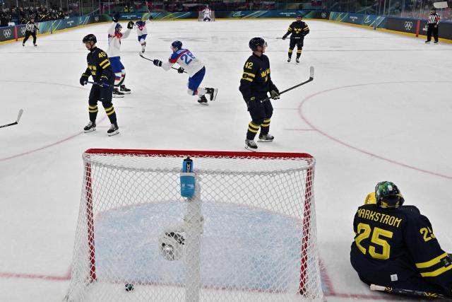 Slovakia's #28 Martin Gernat (2L) celebrates after scoring his team's second goal during the men's preliminary round Group B Ice Hockey match between Sweden and Slovakia at the Milano Santagiulia Ice Hockey Arena during the Milano Cortina 2026 Winter Olympic Games in Milan, on February 14, 2026. (Photo by JULIEN DE ROSA / POOL / AFP)