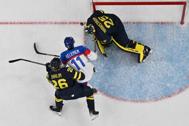 Sweden's #26 Rasmus Dahlin (L) and Sweden's #25 Jacob Markstrom vie for the puck with Slovakia's #11 Milos Kelemen (C) during the men's preliminary round Group B Ice Hockey match between Sweden and Slovakia at the Milano Santagiulia Ice Hockey Arena during the Milano Cortina 2026 Winter Olympic Games in Milan, on February 14, 2026. (Photo by JULIEN DE ROSA / AFP)