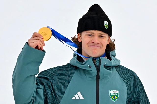 Brazil's gold medalist Lucas Pinheiro Braathen holds up his medal on the podium of the men's giant slalom alpine skiing event during the Milano Cortina 2026 Winter Olympic Games at the Stelvio Ski Centre in Bormio (Valtellina) on February 14, 2026. (Photo by Fabrice COFFRINI / AFP)