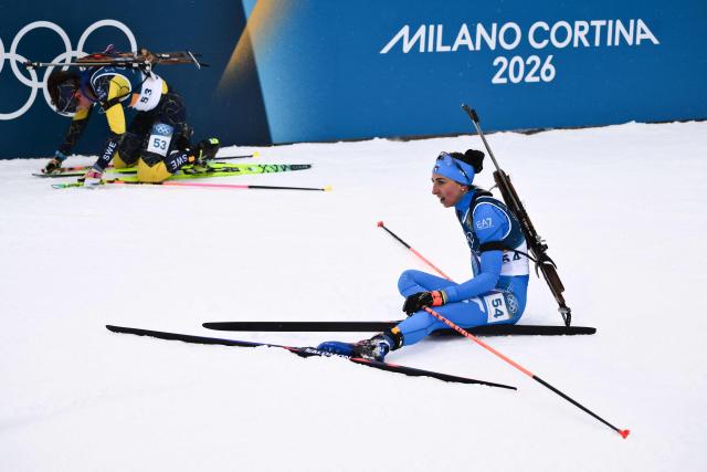 Sweden's Linn Gestblom (L) and Italy's Lisa Vittozzi (R) react after crossing the finish line during the women's biathlon 7,5km sprint event during the Milano Cortina 2026 Winter Olympic Games at the Anterselva Biathlon Arena (Sudtirol Arena) in Anterselva (Val Pusteria) on February 14, 2026. (Photo by Marco BERTORELLO / AFP)