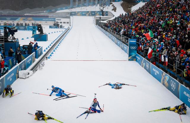 Italy's Lisa Vittozzi (3rd L) and South Korea's Ekaterina Avvakumova (C) react after crossing the finish line during the women's biathlon 7,5km sprint event during the Milano Cortina 2026 Winter Olympic Games at the Anterselva Biathlon Arena (Sudtirol Arena) in Anterselva (Val Pusteria) on February 14, 2026. (Photo by Odd ANDERSEN / AFP)