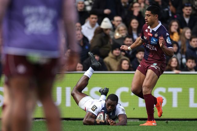 Castres' Cameroonian wing Christian Ambadiang (C) dives to score a try during the French Top 14 rugby union match between Union Bordeaux-Begles (UBB) and Castres Olympique at the Chaban-Delmas Stadium in Bordeaux, south-western France on February 14, 2026. (Photo by Valentine CHAPUIS / AFP)