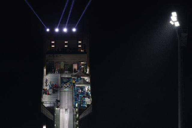 France's Valentin Foubert slides down the inrun track during the trial round of the men's large hill individual ski jumping of the Milano Cortina 2026 Winter Olympic Games at Predazzo Ski Jumping Stadium in Predazzo (Val di Fiemme), on February 14, 2026. (Photo by Anne-Christine POUJOULAT / AFP)