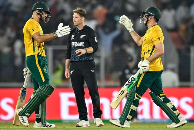 South Africa's captain Aiden Markram (L) and David Miller (R) celebrate their team's win as New Zealand's Lockie Ferguson looks on at the end of the 2026 ICC Men's T20 Cricket World Cup group stage match between New Zealand and South Africa in the Narendra Modi Stadium, Ahmedabad on February 14, 2026. (Photo by Shammi MEHRA / AFP)