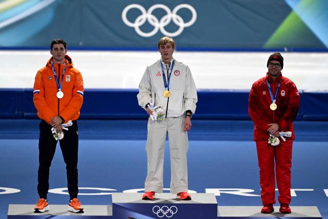 (L-R) Silver medallist Netherlands' Jenning de Boo, gold medallist USA's Jordan Stolz and bronze medallist Canada's Laurent Dubreuil pose on the podium of the speed skating men's 500m during the Milano Cortina 2026 Winter Olympic Games at Milano Speed Skating Stadium in Milan on February 14, 2026. (Photo by Daniel MUNOZ / AFP)